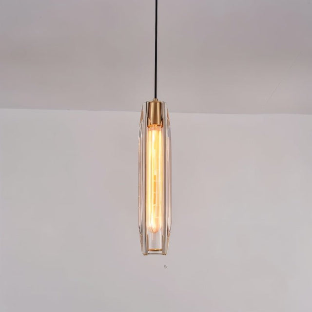 "Minimalist pendant light featuring an elongated, faceted crystal shade and brass frame, refracting light beautifully for a captivating glow."