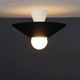 "The Glome Ceiling Lamp in black and white combination, emphasizing its artistic geometric design with a central globe bulb, installed in a dark-themed room for modern elegance."