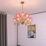 Gloral Chandelier with twelve pink glass globes and gold frame, illuminating a contemporary living space with ambient lighting.