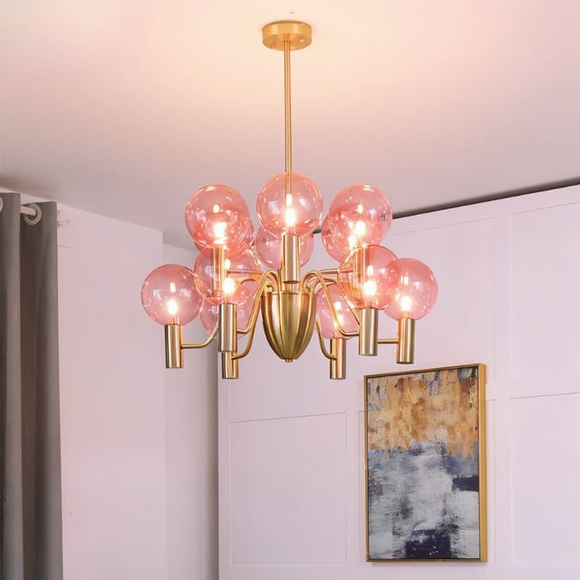 Gloral Chandelier with pink glass bulbs and gold frame, mounted in a modern living room for chic and warm lighting ambiance.