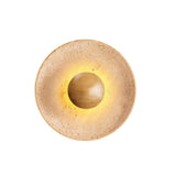 "A modern, circular wall lamp made of yellow travertine with a walnut wood center, isolated on a white background, showcasing its sleek, minimalist design."