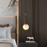 Gong Alabaster Pendant Light hanging in a stylish bedroom, offering a warm glow and contemporary elegance with its alabaster marble finish.