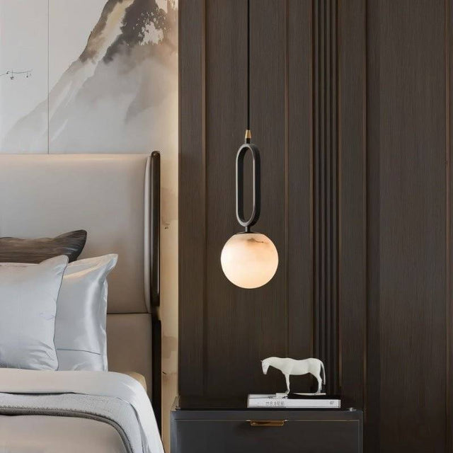 Gong Alabaster Pendant Light hanging in a stylish bedroom, offering a warm glow and contemporary elegance with its alabaster marble finish.