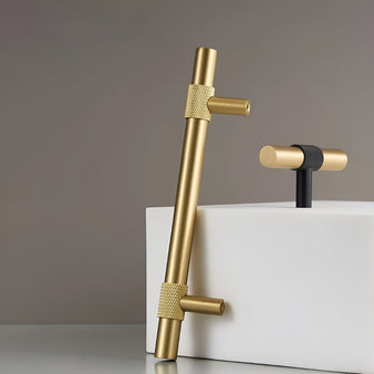 "Pair of modern brass handles, one a pull bar and the other a knob, with brushed gold and black knurled finishes."