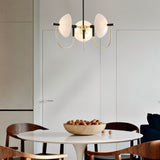 "Modern gold three-light chandelier with frosted glass orbs over a dining table."