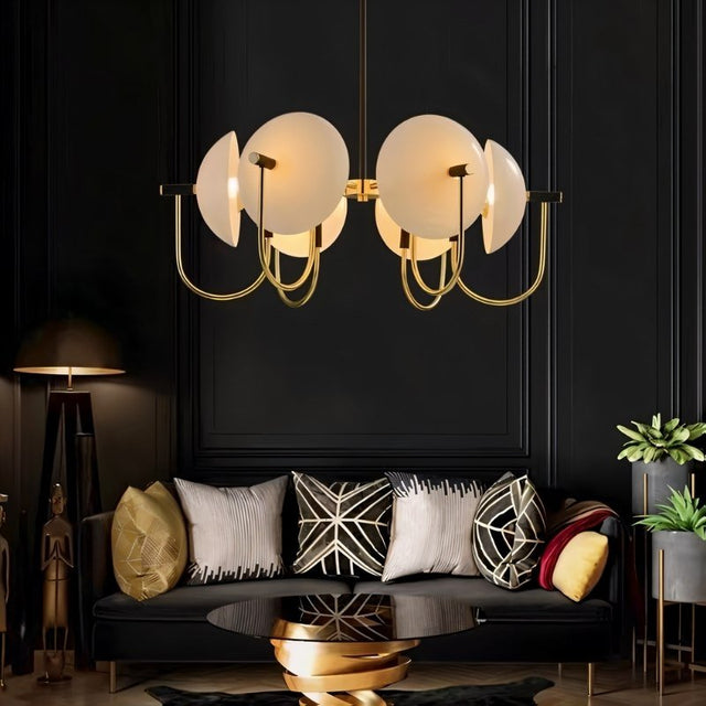 "Modern gold six-light chandelier with frosted glass orbs in a living room."
