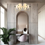 "Modern gold six-light chandelier with frosted glass orbs hanging over a vanity."