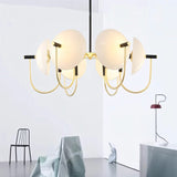 "Modern gold six-light chandelier with frosted glass orbs in a white room."