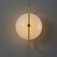 "Close-up of a wall lamp with a brass frame and frosted glass globe, showing its symmetrical design and warm, diffused light."
