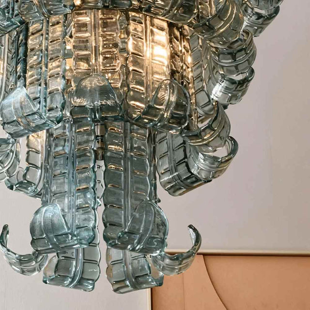 "Detailed view of the textured glass elements of a tiered glass chandelier."