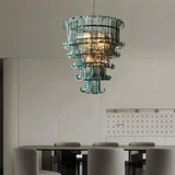 "A tiered glass chandelier hanging above a dining table in a dining room."