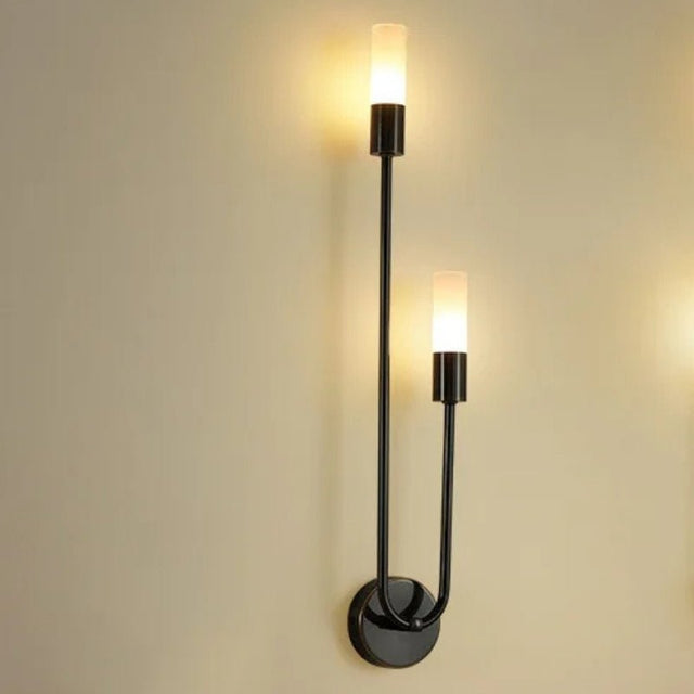 "A modern black wall light with acrylic diffusers on a light-colored wall."