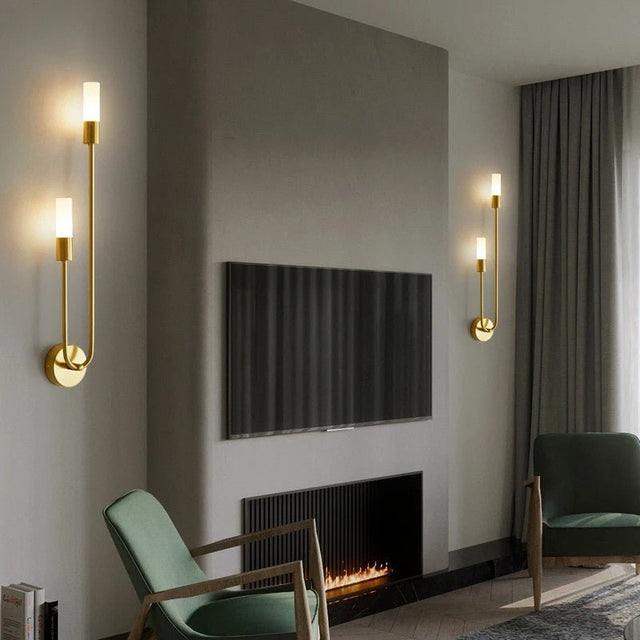 "Two modern brass wall lamps with acrylic diffusers flanking a TV in a living room."