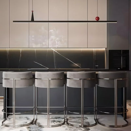 "Linear pendant light over a kitchen island with gray stools."