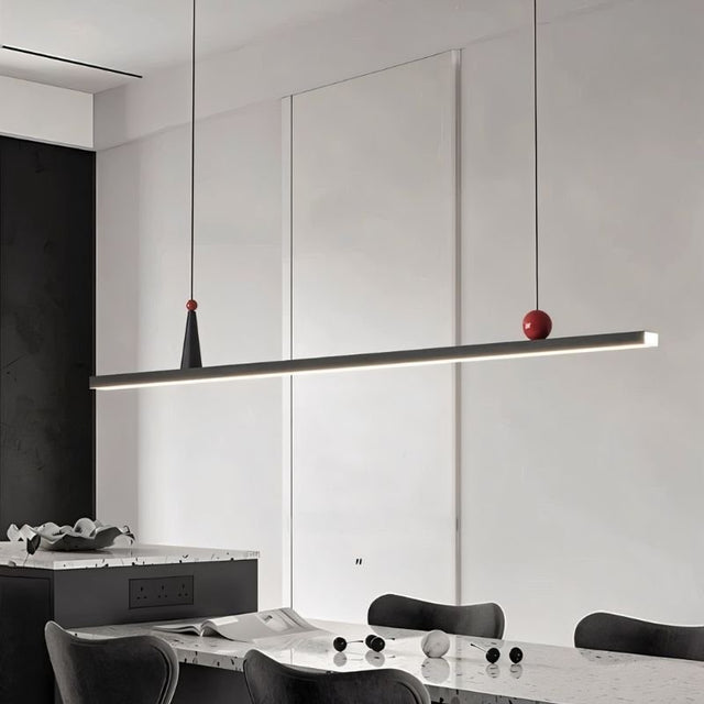 "Modern linear pendant light with black frame and small red and white accents."