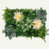 Artificial green wall panel with assorted flowers and foliage on a white background, rectangular shape, synthetic materials.