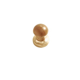 "A modern knob featuring a rounded wooden top and a golden metallic base, designed for contemporary or rustic interiors."