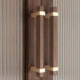 "Modern wooden pull bars with gold metallic brackets on a cabinet with fluted glass doors."