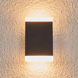 "Modern minimalist Helor wall lamp with a black finish, offering soft illumination in dual directions, enhancing the aesthetics of contemporary interiors and exteriors."