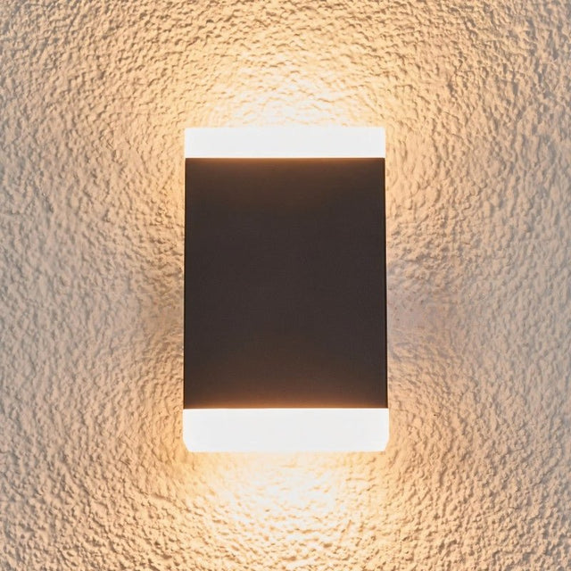 "Modern minimalist Helor wall lamp with a black finish, offering soft illumination in dual directions, enhancing the aesthetics of contemporary interiors and exteriors."