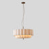 Hetis Pendant Light features a layered design in soft white and gold accents, displayed against a plain white studio backgrou