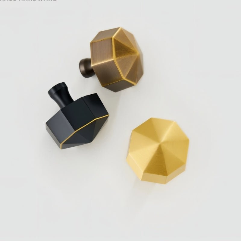 "Top-down view of three hexagonal brass knobs in bronze, black, and gold on a light background."
