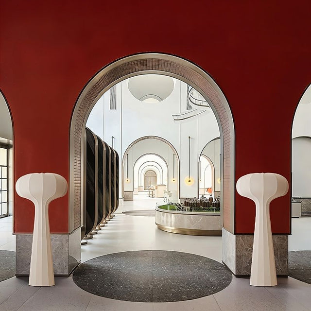 "Sculptural floor lamps with a minimalist design, positioned in a grand interior with arched architecture, featuring flared tops and streamlined silhouettes, crafted from high-quality material."