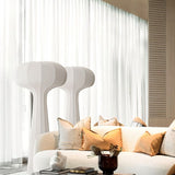 "Elegant sculptural floor lamps in a contemporary living room with soft lighting and decorative cushions, designed with a streamlined silhouette and crafted from high-quality material."