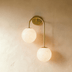 Two-light pendant fixtures with swirled glass globes shown in front and side views against white background.