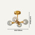Brass sputnik chandelier with four clear glass spheres on cream background.