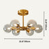 Gold sputnik chandelier with six clear glass globes on a cream background.