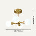 Brass mid-century modern chandelier with four frosted glass globes against a neutral beige background.