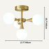 Brass semi-flush ceiling chandelier with three frosted white glass globes against a neutral background.