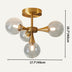 Gold mid-century chandelier with four frosted glass globe shades on a cream background.