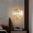 "A tiered crystal pendant light with a brass frame, hanging in a bedroom."