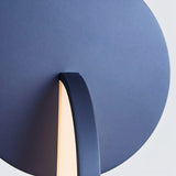 "Close-up detail of a modern blue pendant light with overlapping discs."