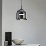 "A modern pendant light with a smoked glass shade hanging in a minimalist setting."