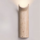 "Modern Ilana wall lamp, crafted from travertine, showcasing its unique curved design and providing a soft, ambient glow."