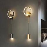 "Two modern wall lamps, one black and one gold, with circular acrylic diffusers and adjustable cylindrical lights."