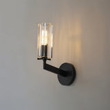 "A modern black wall lamp with a minimalist yet luxurious design, featuring a sleek iron base and a cylindrical glass shade casting a soft, ambient light."