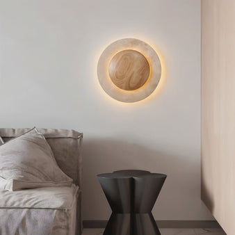 "Circular wall lamp with a travertine stone frame and wood center in a modern bedroom setting."