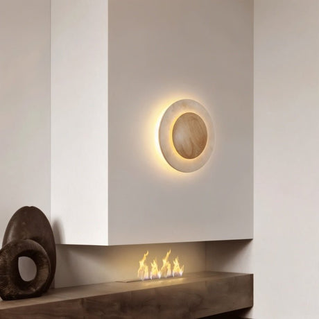 "Circular wall lamp with a travertine stone surround and wood center mounted above a modern fireplace."