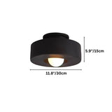 "Black circular flush mount ceiling light with recessed bulb."