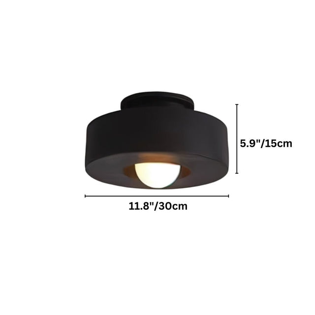 "Black circular flush mount ceiling light with recessed bulb."