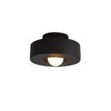 "Black circular flush mount ceiling light with recessed bulb."