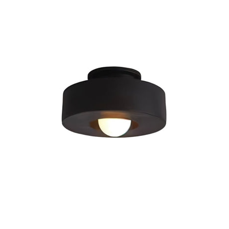 "Black circular flush mount ceiling light with recessed bulb."
