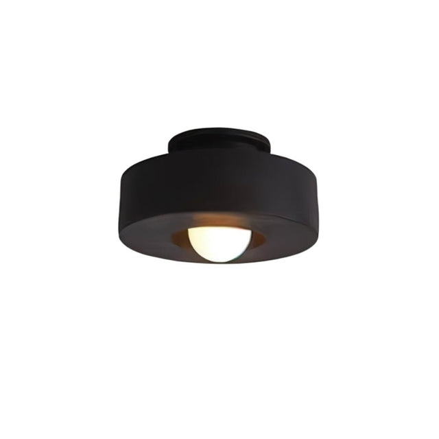 "Black circular flush mount ceiling light with recessed bulb."