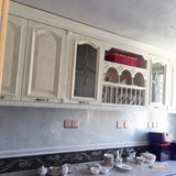 Kacakar Mosaic Tiles applied as a backsplash under white cabinets, adding a shimmering touch to the kitchen wall panel.