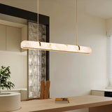 "Modern alabaster chandelier with a sleek copper frame illuminating a contemporary dining room."