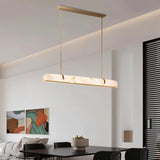 "Modern alabaster and copper linear chandelier providing soft, diffused light in a contemporary living room."